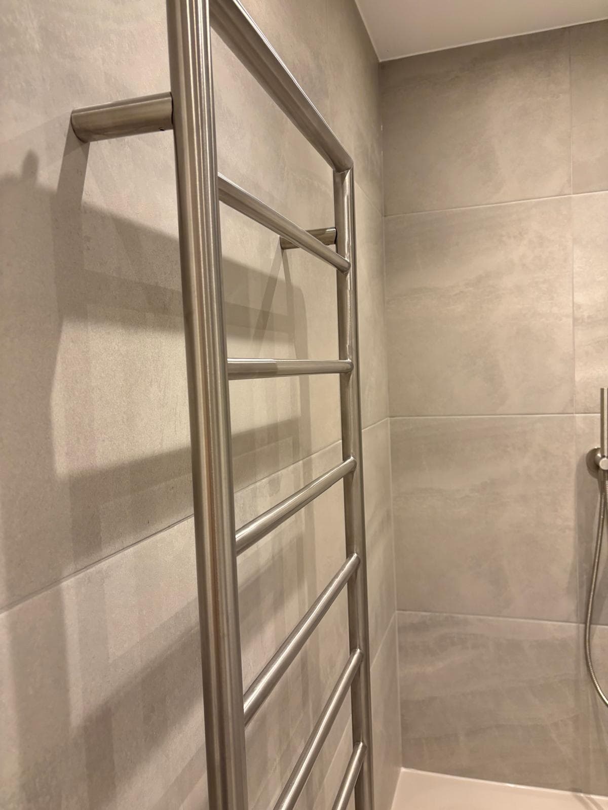 Brushed stainless heated ladder towel rail, contemporary bathroom design London